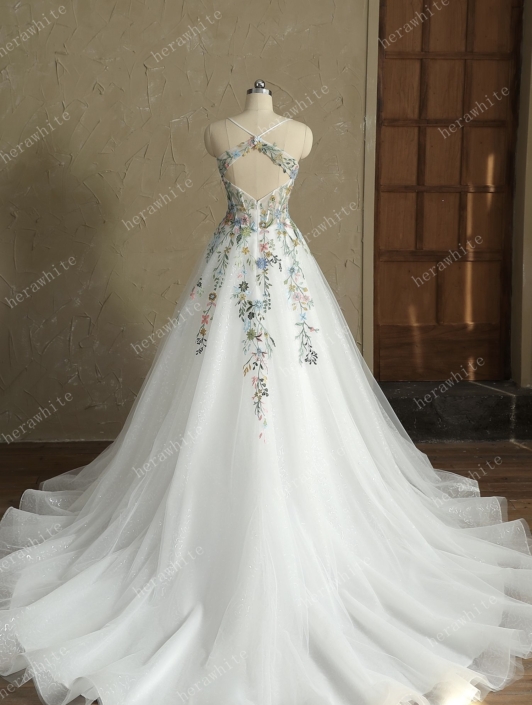 Robe de mariée April de chez Herawhite. Cette magnifique robe de mariée est en tulle parsemée de sequins avec un haut en applique de dentelle fine colorées. Venez découvrir cette robe de mariée chez Rêve d'un Jour à Yvetot