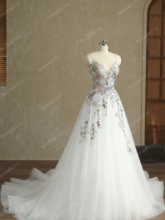 Robe de mariée April de chez Herawhite. Cette magnifique robe de mariée est en tulle parsemée de sequins avec un haut en applique de dentelle fine colorées. Venez découvrir cette robe de mariée chez Rêve d'un Jour à Yvetot