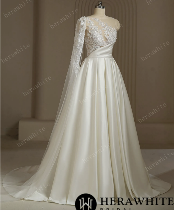 Robe de mariée Azalée. C'est une robe de mariée en satin plissé avec un bustier en tulle serti de sequins tout en transparence. Cette robe de mariée est disponible dans votre boutique Rêve d'un Jour à Yvetot situé entre Rouen et Le Havre