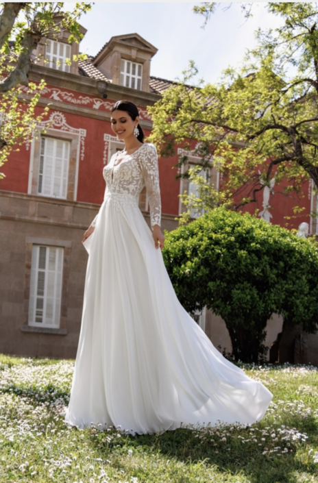 Robe de mariée Holly. C'est une robe de mariée en mousseline avec un bustier avec manches en dentelle. Cette robe de mariée est disponible dans votre boutique Rêve d'un Jour à Yvetot situé entre Rouen et Le Havre