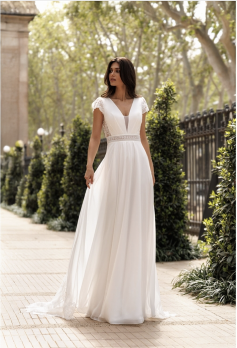 Robe de mariée Pivoine. C'est une robe de mariée en mousseline avec un bustier dentelle avec un dos papillon. Une magnifique traine orné de la dentelle du bustier. Cette robe de mariée est disponible dans votre boutique Rêve d'un Jour à Yvetot situé entre Rouen et Le Havre